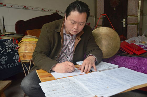 梁平癩子鑼鼓傳承人、全國優(yōu)秀文化志愿者賀志燦整理癩子鑼鼓的相關(guān)資料。通訊員 謝清城 攝